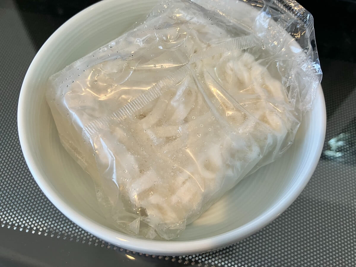 やわらかいミニうどんを内袋のまま皿においてレンジで温める前の状態